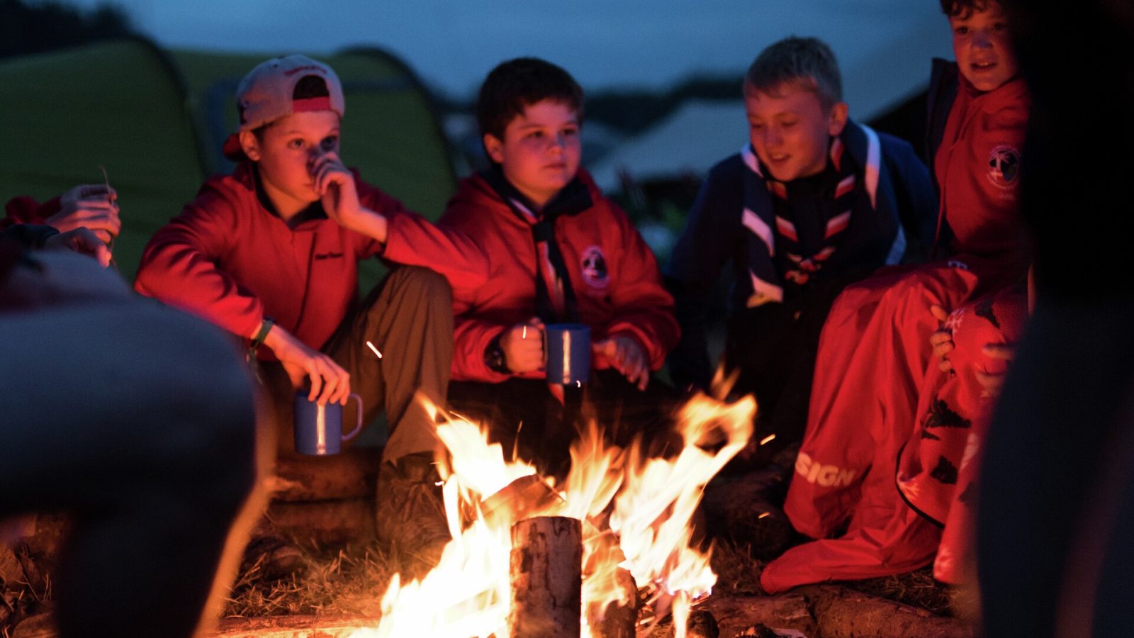 KFUM-gruppen, Østerhøj-Måløv fra Ballerup, har sin venskabsgruppe fra Hensingham i England med på lejr. Her nyder de deres internationale lejr ved aftenbålet sidste aften på Spejdernes Lejr 2017. Foto: Pernille Bille Tvedt