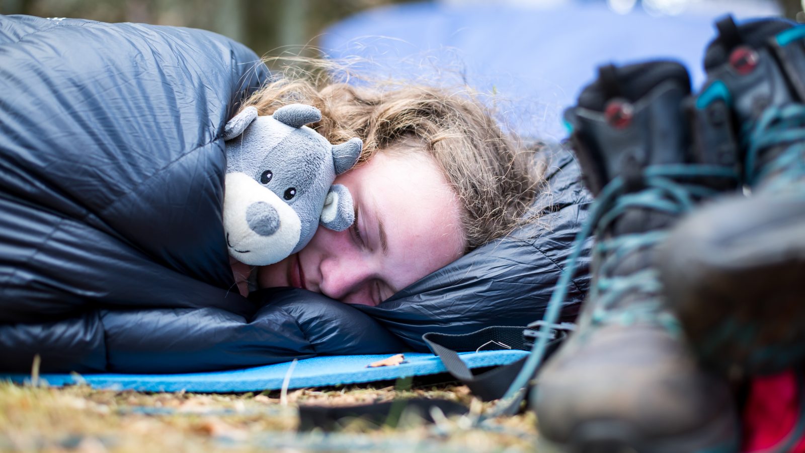 Spejder sover i sovepose med bamse