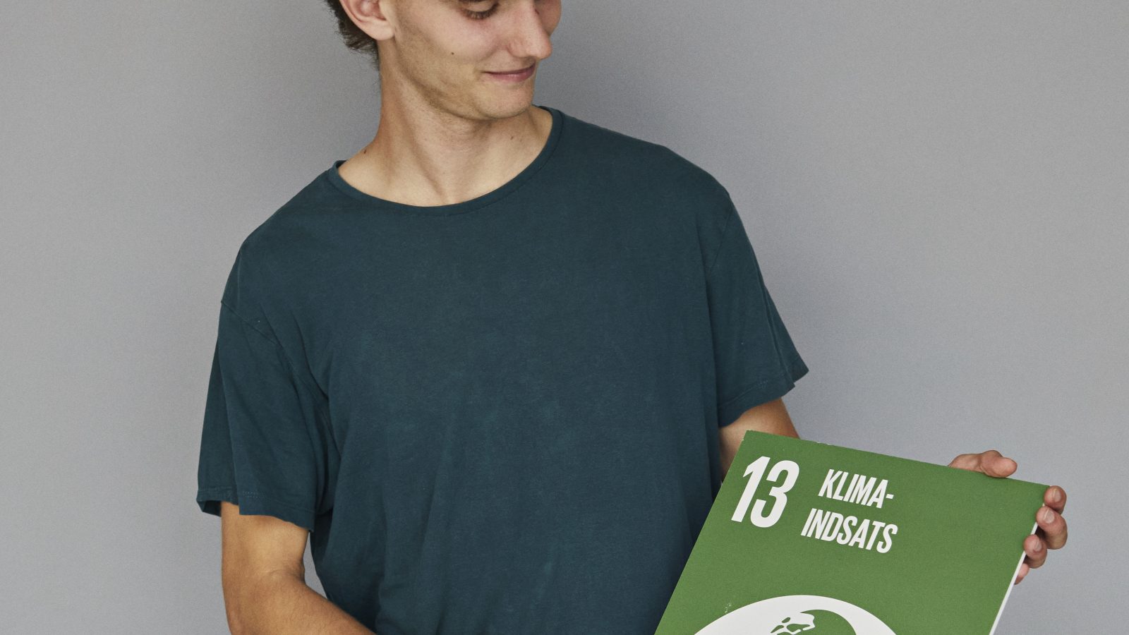 Sigurd Krabbe står med et skilt der viser FN's klimaråd