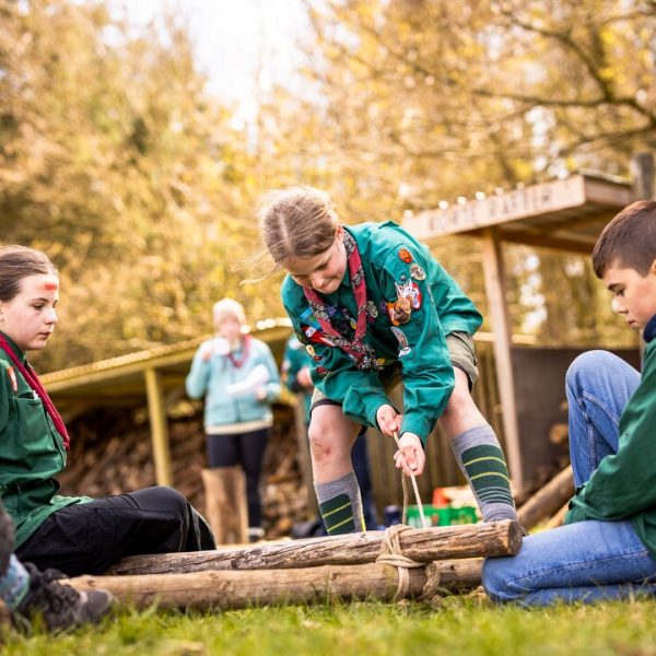 Unge i uniform strammer reb om rafter (Jens Granes Fond)