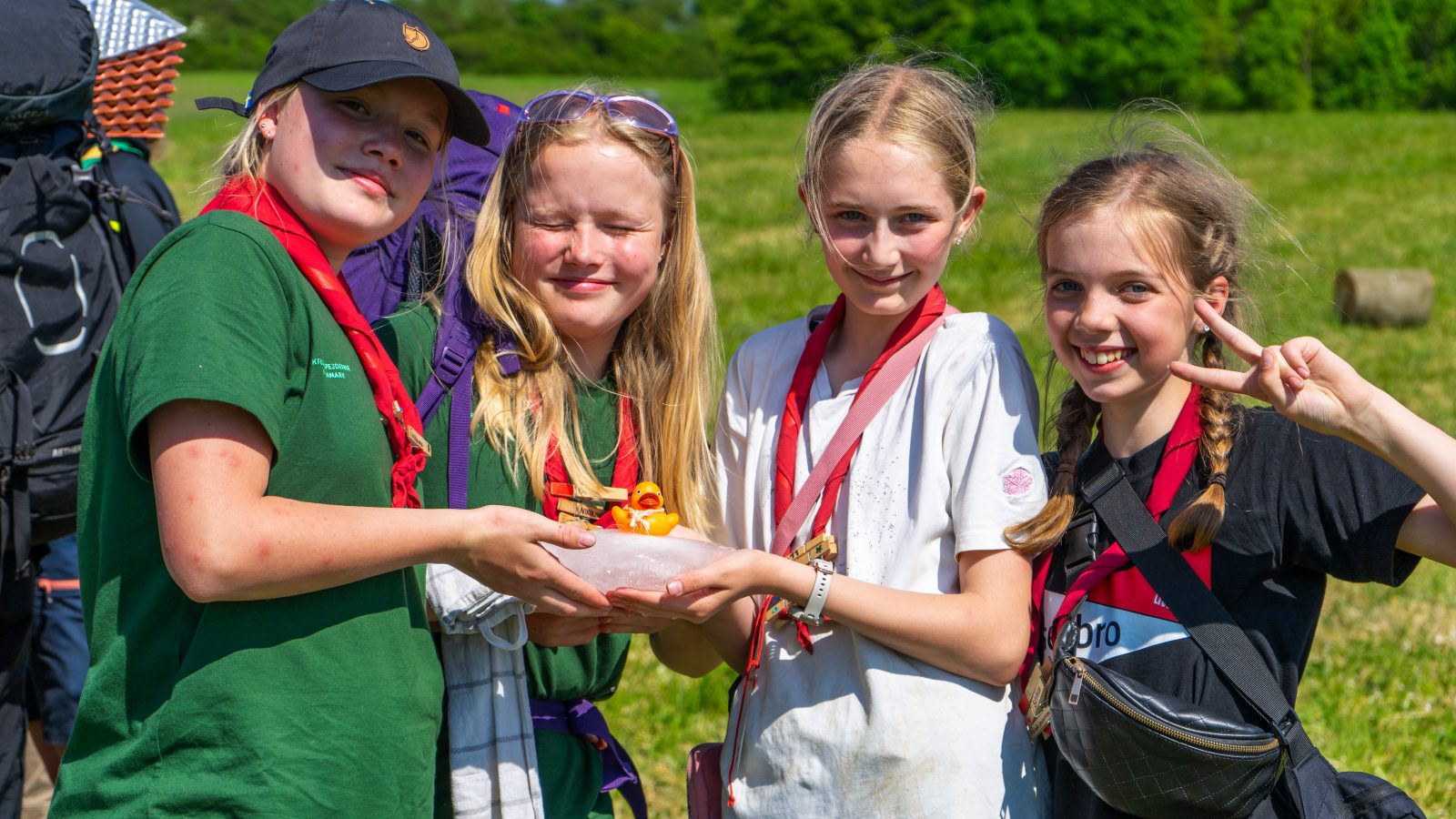 Fire spejdere kigger glade ind i kameraet.