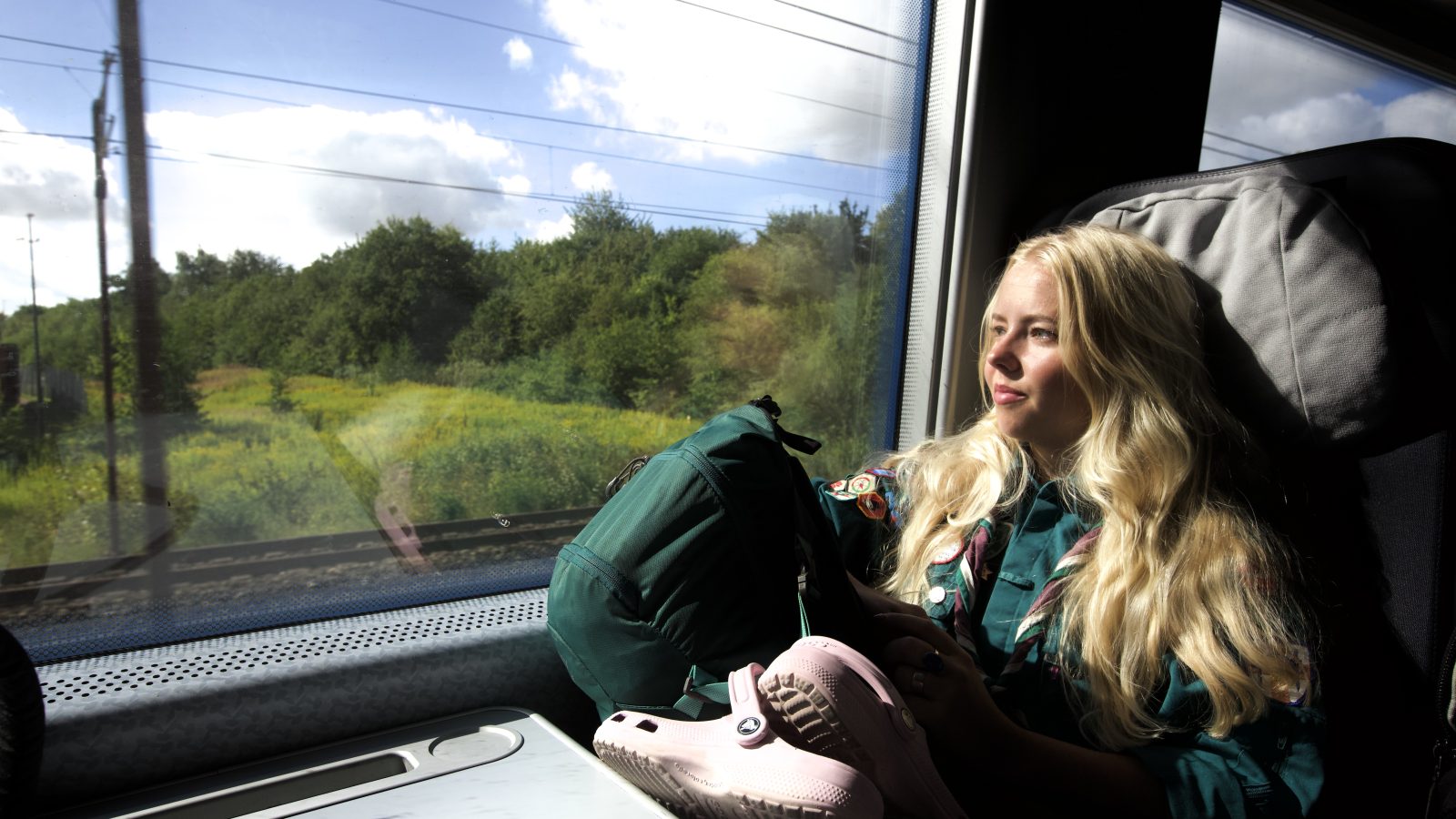 Spejder kigger ud ad vinduet i toget.