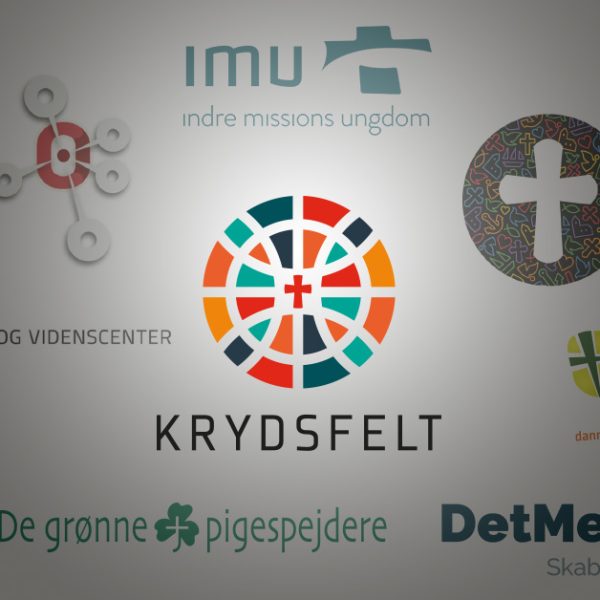 To spejderledere viser en færdselstavle for en gruppe børn